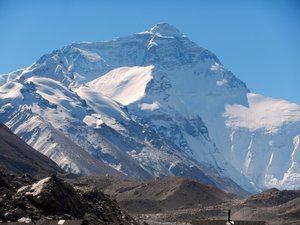 The iconic Mt Everest north face, backed by a blue sky
