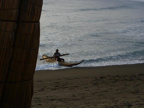 totora reed boat in use - you paddle it with a 2x4