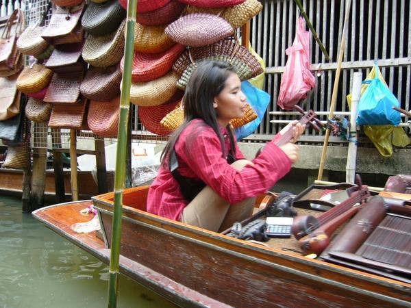 A seller playing her musical instruments