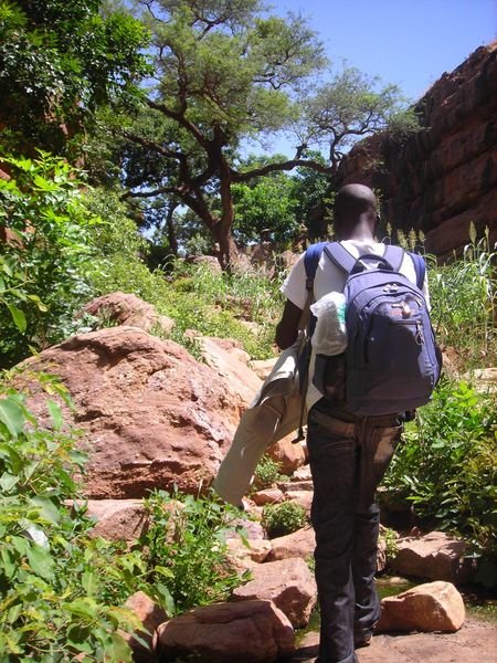 our superhuman guide carrying multiple bookbags as we hiked through more millet up to the village