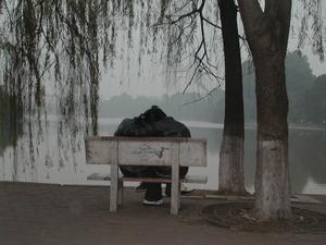 Young lovers at the mist-shrouded Hoan Kiem lake in the Old Quarter, Hanoi