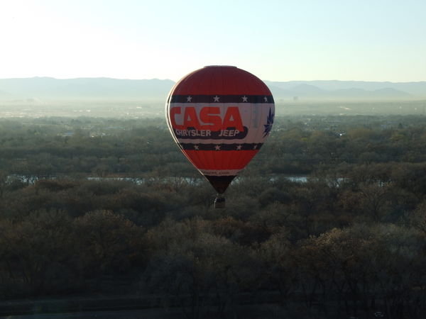 The red balloon flies with some sort of creek in the background.