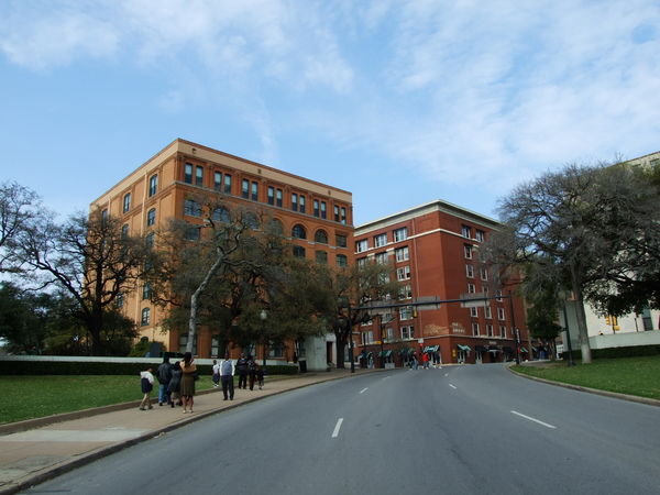 This picture is taken from the X. Left building is the book depository. Top floor, far right window. Easy shot.
