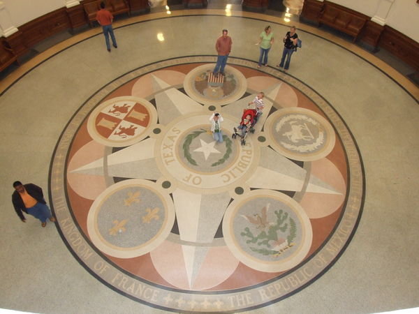 The State Seal, with all six flags that have flown over Texas