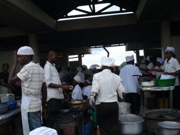 These people are cooking food that will be sold to the workers and customers in the market.