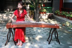 Girl playing Chinese instrument at the Teahouse we visited