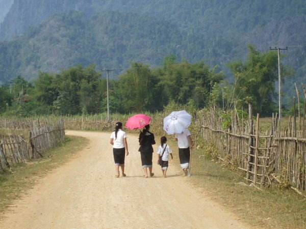 Laos women from the local village using umbrellas to keep their skin whiter