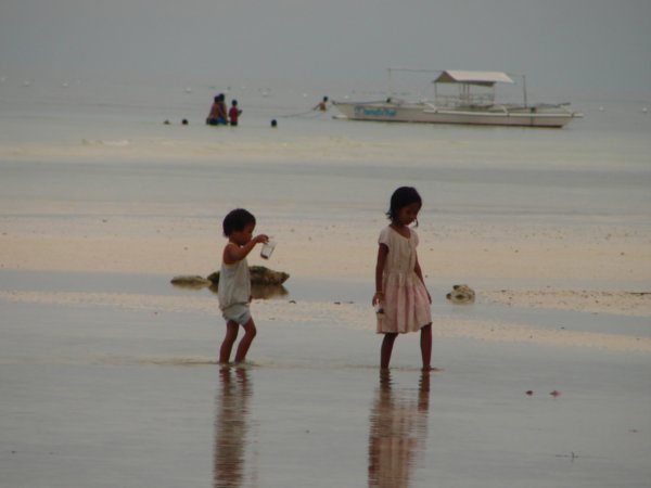 2 little kids out collecting sea creatures at Dumaluan