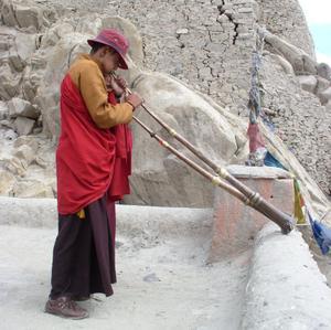 Monk plays the traditional horn, Shey Gompa