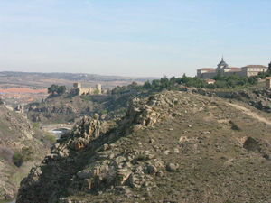 The mountain side surrounding Toledo with a castle in the distance