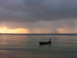 sunset rain and man in boat
