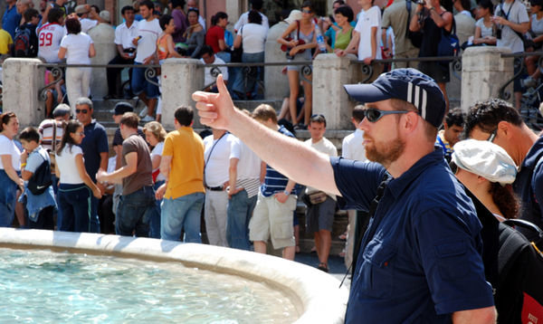Tom tossing a coin into the Trevi Fountain