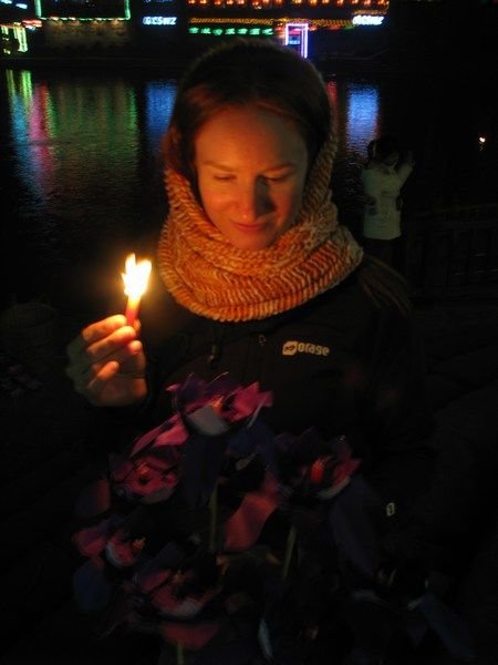Lighting a paper flower boat to send up the river