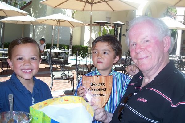 Will and Henry present Grandpa with a "World's Greatest Grandpa" plaque