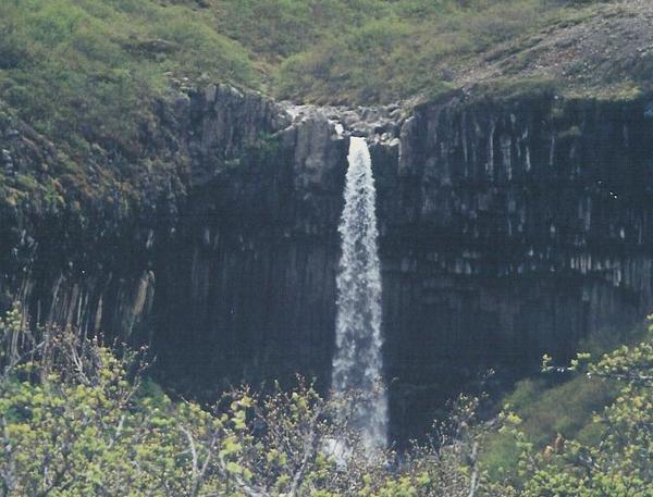 Waterfall surrounded by basalt columns in Skaftafell National Park