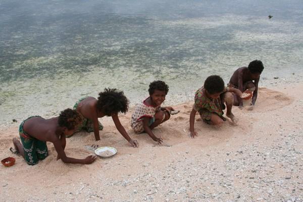 Kids collecting mussels on Kiriwina Island