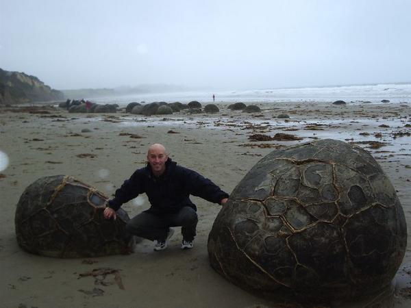 Andy with his hands on 2 big boulders