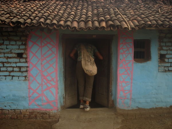 Evan entering a village house