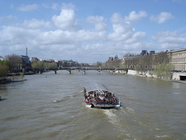 Tour boat taking tourists on a grand tour of paris through the canals