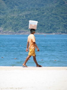 A guy selling something at the beach in Ubatuba