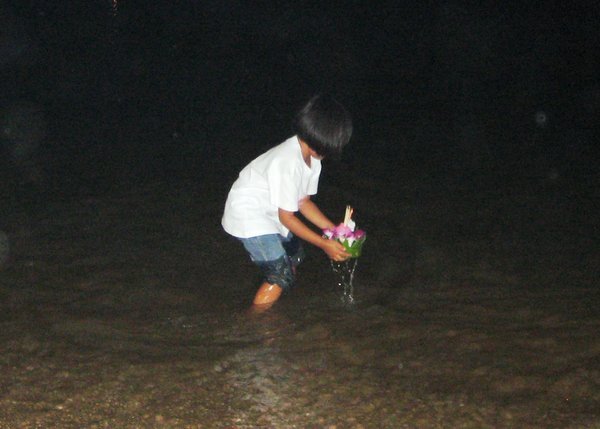A little girl sending her Krathong out to sea