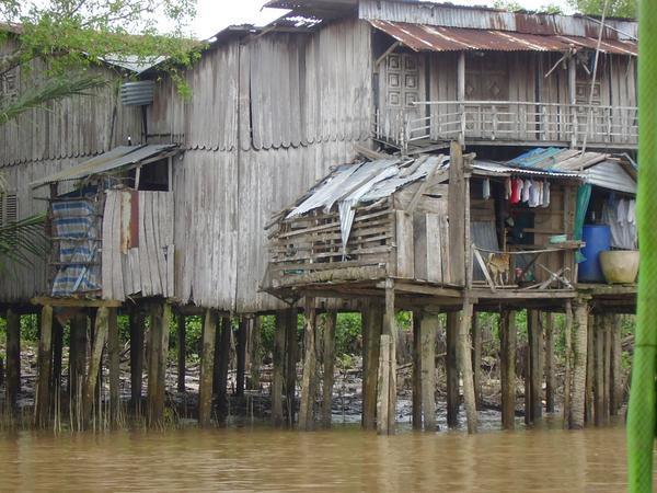 A house on stilts at the edge of the Mekong