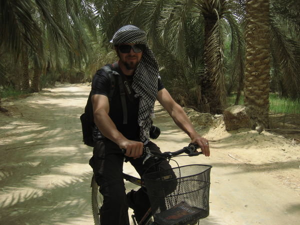 Dan biking through a date palm grove