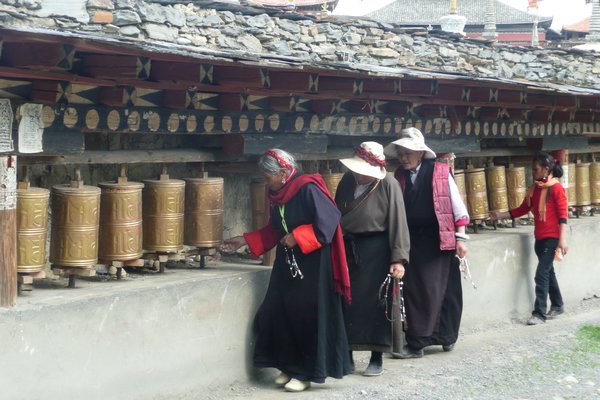 Spinning prayer wheels around Tagong monastery