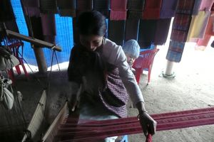 A minority villager shows how to make a rug by hand