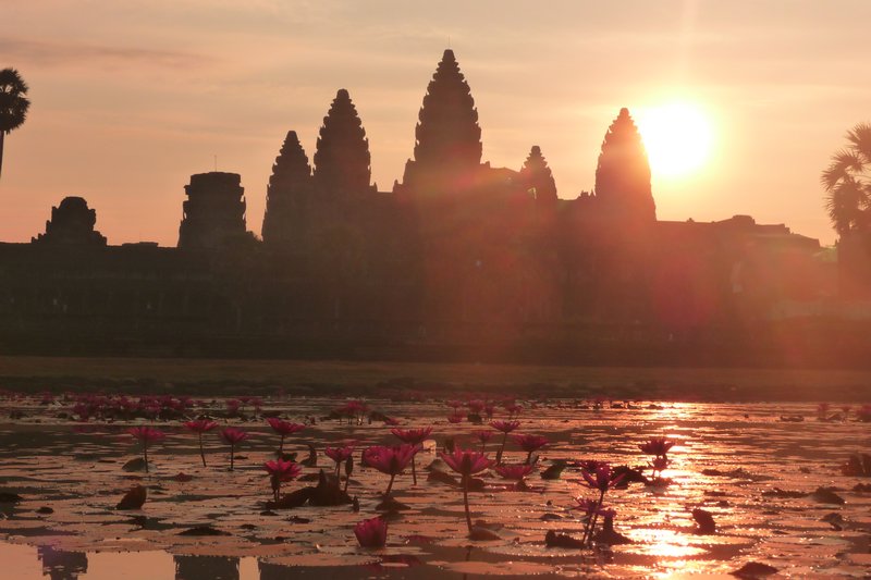 The sun finally peeks up over the South tower of Angkor Wat