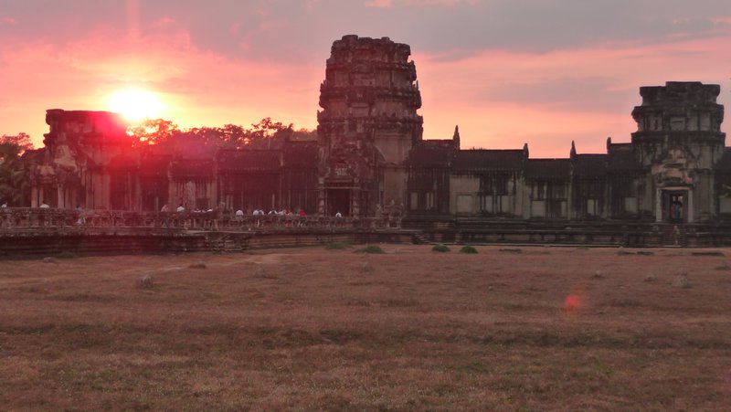 The sun sets over the West gate of Angkor Wat