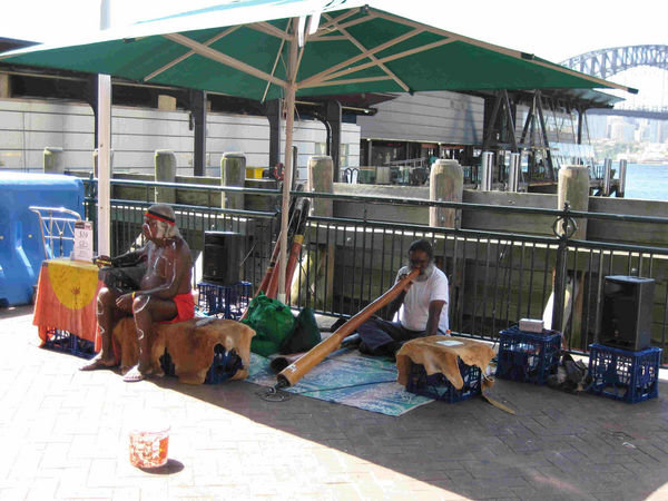 Aboriginals playing the didgeridoo and seeling CDs