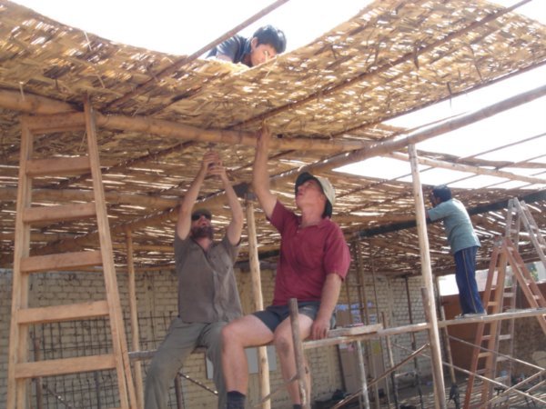 Fixing down the bamboo roof.