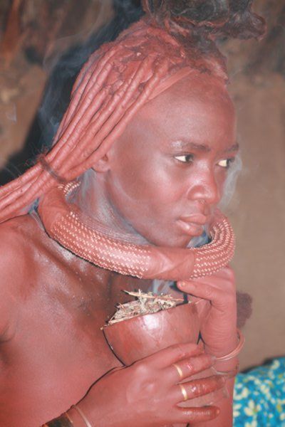 Himba woman cleaning