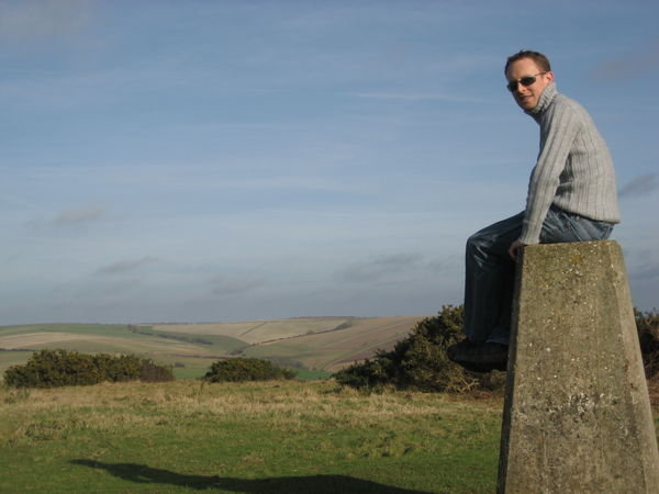 Steve sitting on the triangulation pillar. Cissbury Ring, Sussex