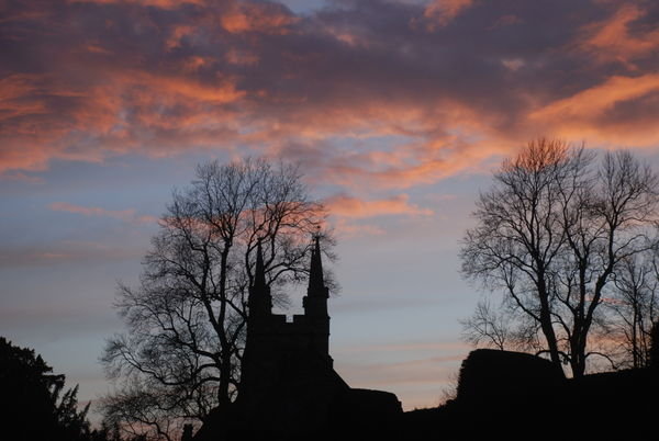 Day is done. Penshurst Church silhouetted against the sky as the sun sets. 