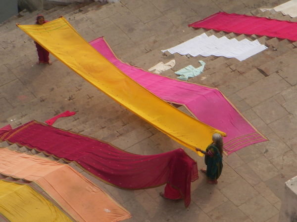 Holding saris so they will dry in the sun