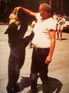 Tourist feeding bear grapes, early on during the park's history