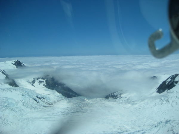 Franz Joseph Glacier wie er unter dem Wolkenmeer ueber der Westkueste verschwindet