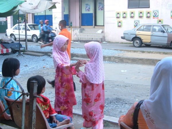little girls playing patty-cake at the bus station