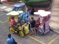Garish trishaws playing loud music filled the streets