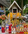 a hum drum spirit house with a lot of figures, fanta, and flowers
