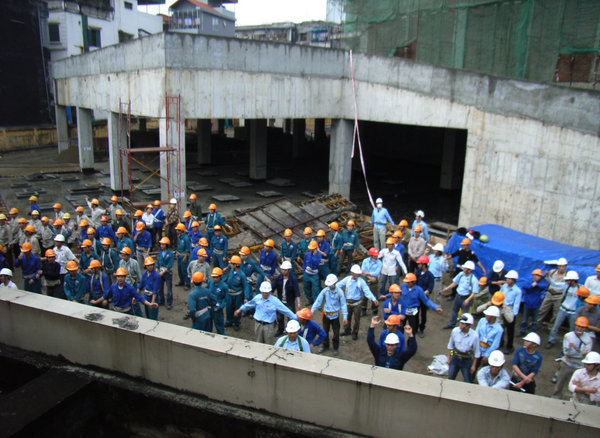 Workers are doing morning exercise on the site 