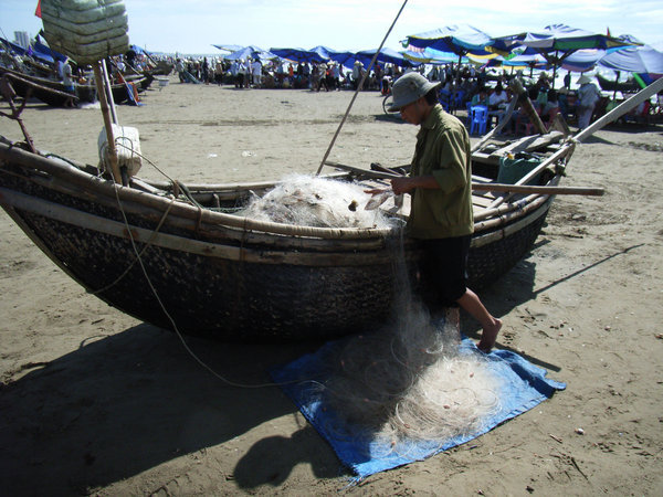 A fisherman & his boat at Sam Son beach