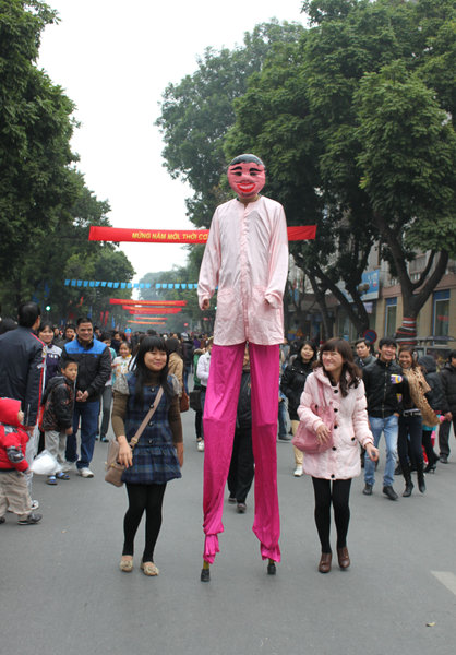 An artist is walking on stilts