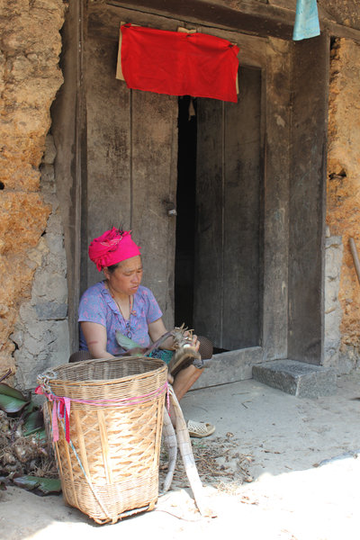 A H'mong woman & her house