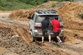 Tour guide and tourist are pushing the car