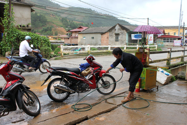 Washing motorbike outside a shop
