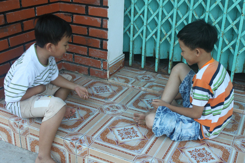 Children playing with stones in Bình Châu town
