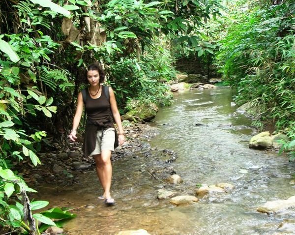Julie wading through a creek